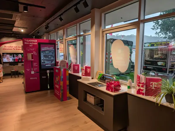 Modernes Telekom-Shop-Interieur mit Glasfaser-Info, Werbeschildern und Geschenktüten.
