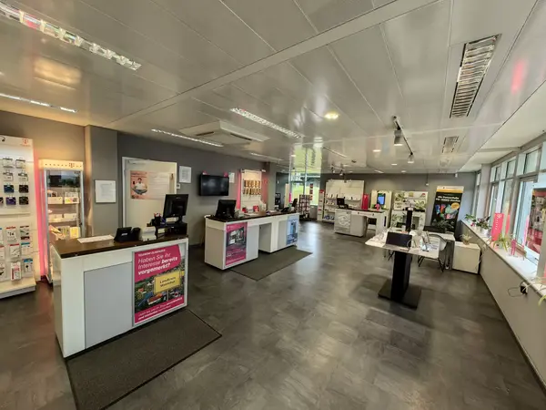 Modernes Telekommunikationsgeschäft mit Beratungstresen, Technikprodukten und Werbedisplays.