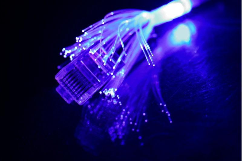 Leuchtendes Glasfaserkabel mit Netzwerkstecker, Symbol für schnelles Internet